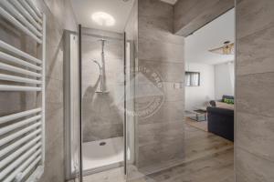 - une douche avec une porte en verre dans la chambre dans l'établissement AS15280 - P3 face à la mer avec garage privé à 2 pas du Centre Ville, au Grau-du-Roi
