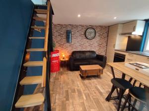 uma sala de estar com uma escada e um sofá em Gîte Ange ou Démon, love room, jacuzzi, sauna, spa em Benfeld
