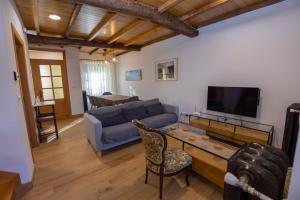 sala de estar con sofá azul y TV en Casa Alameda 33 en Ría Eo-Ribadeo, en Castropol
