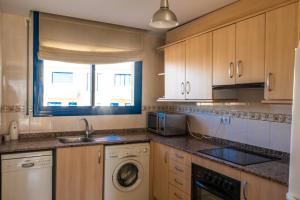 a kitchen with a sink and a washing machine at Mar del Delta in L'Ampolla