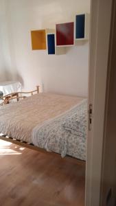 una camera da letto con un letto e alcuni dipinti alle pareti di Casa Salvatore a Messina