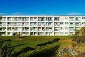 ein großes weißes Gebäude mit einer Wiese davor in der Unterkunft "Strandhotel Heiligenhafen", Wohnung 126 in Heiligenhafen