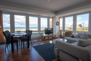 ein Wohnzimmer mit einer Couch und einem Tisch mit Stühlen in der Unterkunft "Strandhotel Heiligenhafen", Wohnung 126 in Heiligenhafen