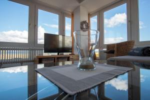 eine Glasvase auf einem Tisch im Wohnzimmer in der Unterkunft "Strandhotel Heiligenhafen", Wohnung 126 in Heiligenhafen