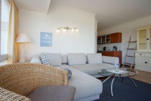 ein Wohnzimmer mit einer Couch und einem Tisch in der Unterkunft "Strandhotel Heiligenhafen", Wohnung 126 in Heiligenhafen