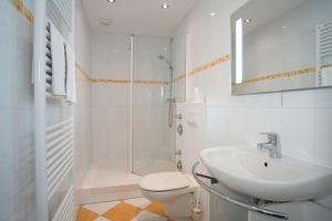 ein Badezimmer mit Waschbecken, Toilette und Dusche in der Unterkunft "Strandhotel Heiligenhafen", Wohnung 126 in Heiligenhafen