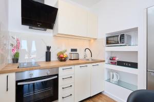 een keuken met witte kasten en een magnetron bij Apartment Evening Star in Dubrovnik