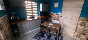 a small kitchen with a wooden table and a stool at LE LAMPEDUSA in Maninghem