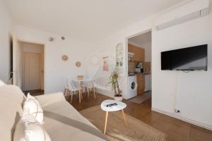 un soggiorno bianco con divano e tavolo di AS20241 - Studio cabine au Centre Ville a Le Grau-du-Roi