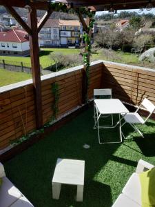 a patio with a table and chairs and a pergola at Hostal Stella Del Mare in Camariñas