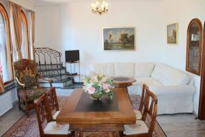 a living room with a couch and a table with flowers at Barony romantic-residence in Lugano