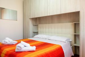 バスティーア・ウンブラにあるCasa del Giardino Bright Apartmentのタオルが敷かれた大きなベッドのある寝室