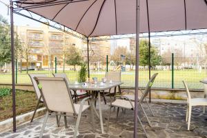 una mesa y sillas bajo una sombrilla en un patio en Casa del Giardino Bright Apartment, en Bastia Umbra