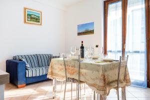 バスティーア・ウンブラにあるCasa del Giardino Bright Apartmentのダイニングルーム(テーブル、青いソファ付)