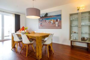 une salle à manger avec une table et des chaises en bois dans l'établissement Ferienhaus-Luv, à Heiligenhafen