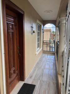 um corredor vazio com uma porta de madeira e um piso em Apartamentos Kika em San Felipe de Puerto Plata