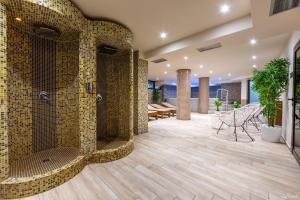 una camera con ampia doccia e pareti piastrellate gialle di Tino Hotel & SPA a Ohrid