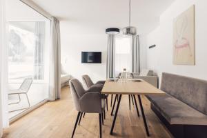 - un salon avec une table, des chaises et un canapé dans l'établissement Sima-Apartments, à Längenfeld