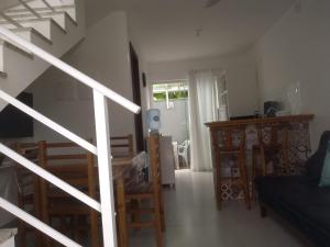 ein Wohnzimmer mit einer Treppe und einem Tisch und Stühlen in der Unterkunft Residencial Farol das Conchas in Bombinhas
