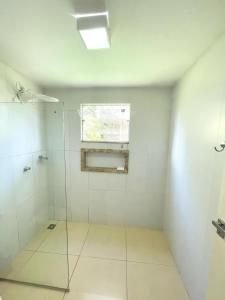 Un baño con ducha de cristal y ventana. en Suite Confortavel em Chapada dos Guimaraes, en Chapada dos Guimarães 16 fotos más