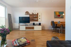 ein Wohnzimmer mit einem TV und einem Esszimmer in der Unterkunft Haus "Wilhelmsplatz", Wohnung "Heimathafen" in Heiligenhafen