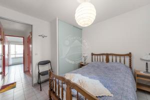 a bedroom with a bed and a chair in it at AS16245 - P2 Belle vue lac avec parking privé in Le Grau-du-Roi