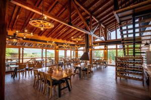 a dining room with tables and chairs in a building at Malak Farma in Kakanj