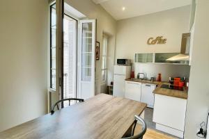 a kitchen with a wooden table and chairs in a room at Renovated Furnished Apartment in The Heart of Historic Bordeaux in Bordeaux