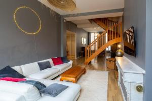 een woonkamer met een witte bank en een trap bij Contemporary Furnished Duplex With 3 Bedrooms Near All Amenities in Bordeaux