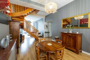 een eetkamer met een houten tafel en een trap bij Contemporary Furnished Duplex With 3 Bedrooms Near All Amenities in Bordeaux