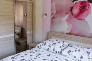 een slaapkamer met een bed met een bloemschilderij aan de muur bij Apartament 15 Delux- Bliżej Zdroju in Polanica-Zdrój