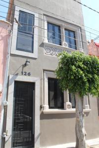 un edificio con una puerta y un árbol delante de él en La Casa Mia Leon en León