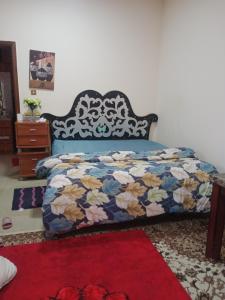 El AinにあるTransient furnished room 1 minute to Al aijn mallの赤いカーペットフロアのベッドルーム1室(ベッド1台付)