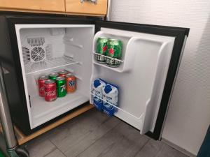 an open refrigerator with drinks and soda in it at Little house in Amsterdam in Amsterdam