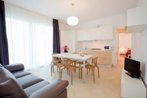 Appartamenti Emma في كاورلي: مطبخ وغرفة معيشة مع طاولة وكراسي