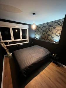 - une chambre avec un lit et une carte murale dans l'établissement Appartement moderne full black Dunkerque centre, à Dunkerque