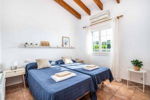 a bedroom with a blue bed and a window at Villa Mimosa in Binibeca +17 photos