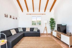 a living room with a couch and a tv at Villa Mimosa in Binibeca