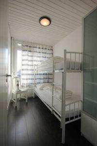 Un dormitorio con dos literas y una ventana. en Appartement Walvis nr. 14B, en Vrouwenpolder