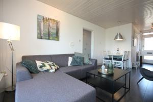 una sala de estar con un sofá y una mesa en Appartement Walvis nr. 14B, en Vrouwenpolder