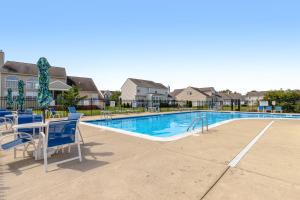 Una piscina con sillas azules y una mesa con una mesa. en Wedgefield -- 1 Wedgefield, en Ocean View