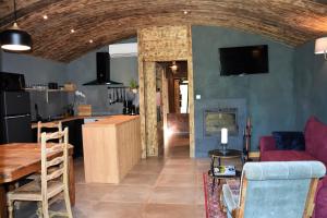 Una cocina y una sala de estar con un sofá y una mesa. en Estiva Resort, en Lapeyrugue