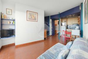 uma sala de estar com um sofá e uma cozinha em AS8313 - P2 cabine avec parking privé, accès direct à la plage em Le Grau-du-Roi