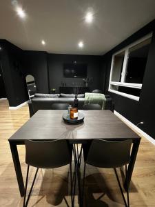 y sala de estar con mesa de comedor y sillas. en Appartement moderne full black Dunkerque centre, en Dunkerque