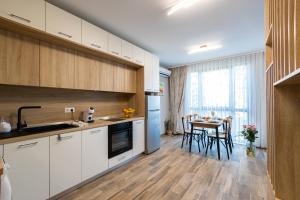 a kitchen with white cabinets and a table with chairs at Helena Holiday A in Saints Constantine and Helena