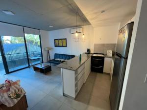 een keuken en een woonkamer met een bank en een koelkast bij Nuevo Riverside II Ubicado estratégicamente piscina gym laundry cochera in Tigre