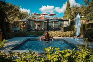 a woman in a swimming pool in a house at Hotel****Spa & Restaurant Cantemerle in Vence