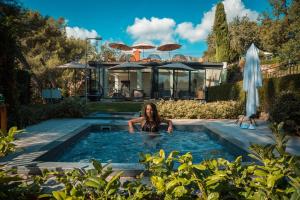 a woman in a swimming pool in a house at Hotel****Spa & Restaurant Cantemerle in Vence