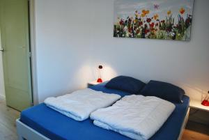 1 cama en una habitación con un cuadro en la pared en Appartement Walvis nr. 16B, en Vrouwenpolder