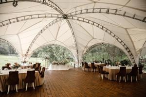 una tienda de campaña para una boda con mesas y sillas en Flagman Hotel, en Novovolkovo